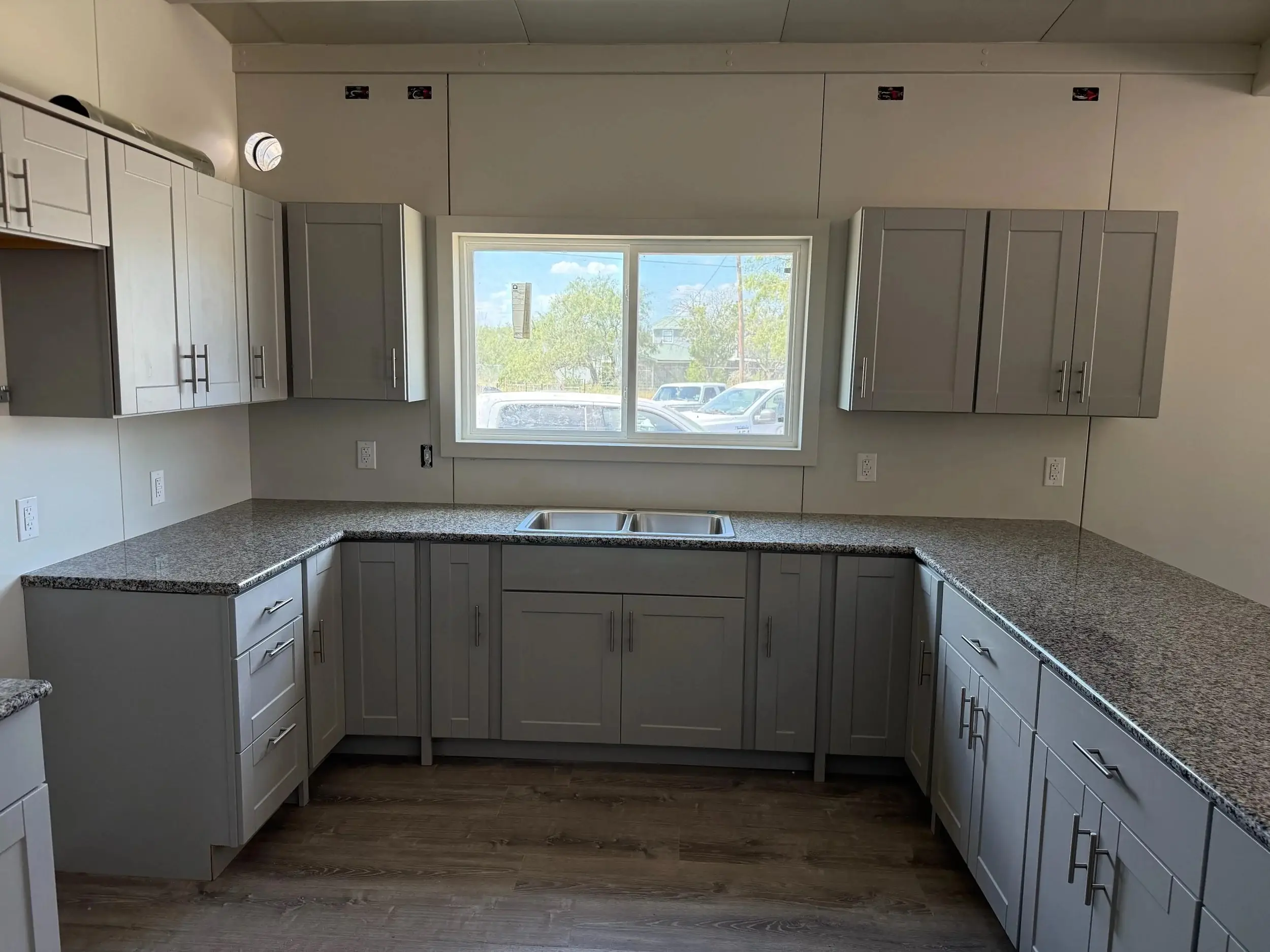 Finished kitchen with granite countertops and gray shaker cabinetry